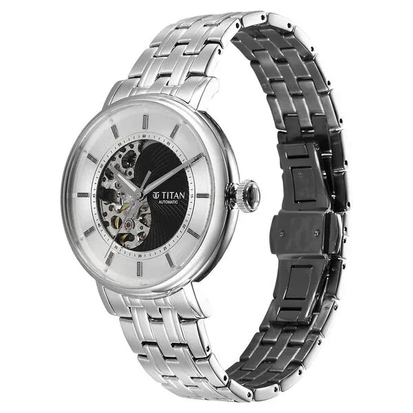 Lifestyle image of a young professional checking the time on his wrist while walking through a sunlit modern office corridor